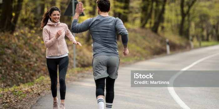 Happy athletic couple having fun while running in spring day